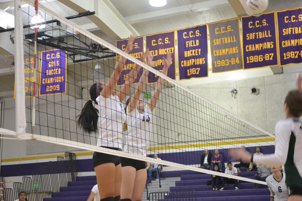 Freshman Kelly Bishop and junior Hannah Pollek jump to block Homestead's spike on Oct. 3. Photo by Colin Kim