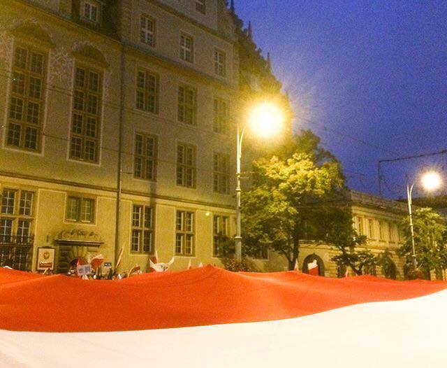 Protesters in Gdańsk unfurl a Polish flag outside of a courthouse. Photo used with permission from Jeremi Kalkowski.