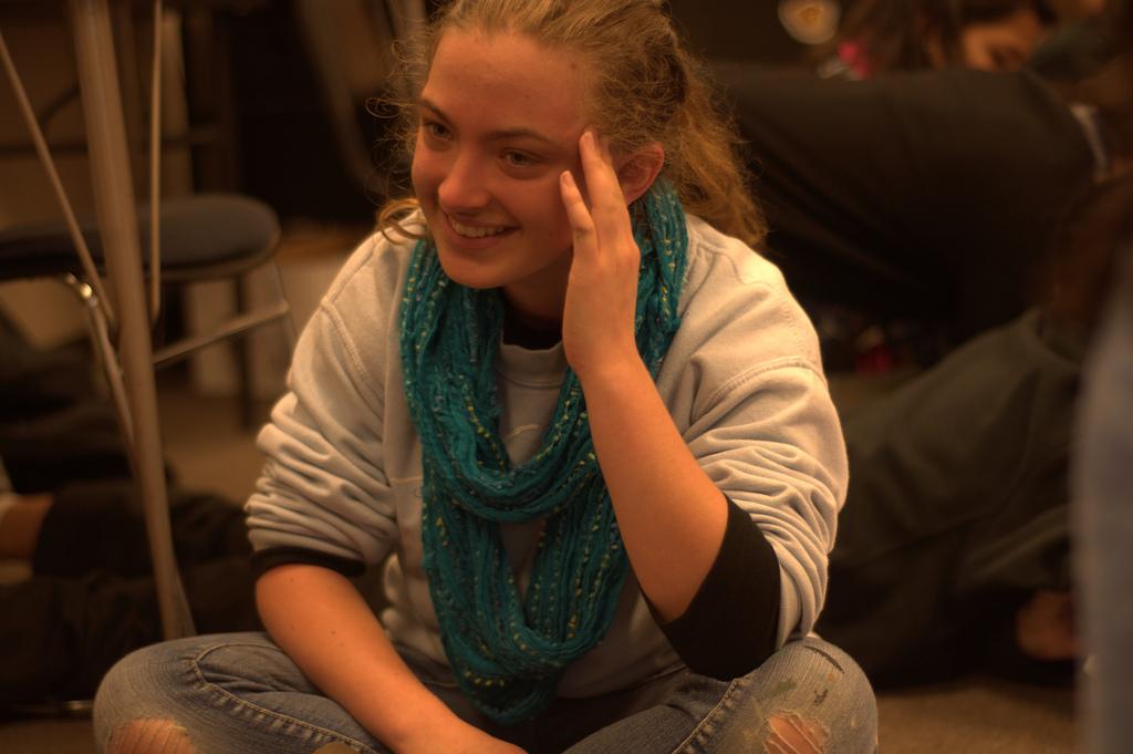 Senior Simone Becker sits cross-legged, listening to a humorous story from a fellow student. At the latest Peer Counseling meeting, the members of the club decided to play some coloring games as a way to develop friendships and relieve stress. Photo by Colin Ni.