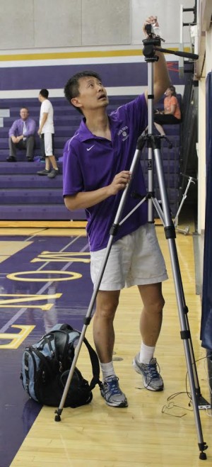 Ernest Hua prepares his camera to record the MVHS varsity girls volleyball game against Palo Alto High School. Photo by Sanjana Murthy.