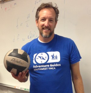 Girls volleyball coach Colin Anderson poses with his volleyball in his math classroom. To Anderson, volleyball is a fun, entertaining sport that can be played anywhere and anytime.  