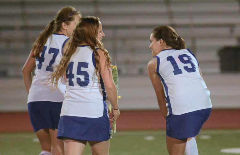 Senior Katie Sommers walks across the field with seniors Andi Pappas and Michelle Lentfer after senior recognition. They were three of the seven field hockey seniors recognized and ready to play their last home game on a MVHS field. Photo by Malini Ramaiyer.