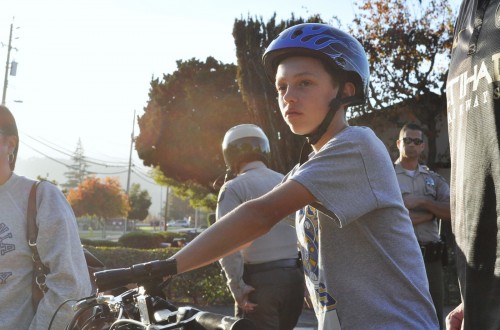A young boy waits to begin the ride as police officers stand in the background. The officers checked in with the group before the event started.