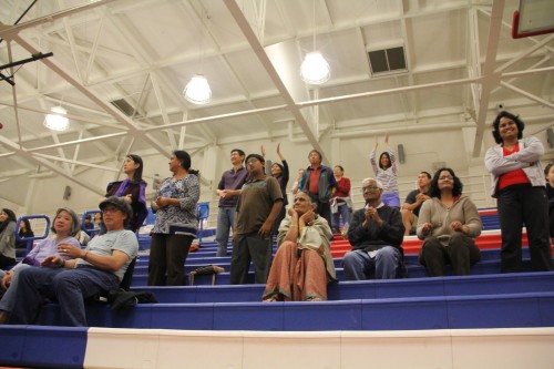 Parents and other fans stood up for a game point. Throughout the match they started cheers that grew louder as each play progressed; however, they always fell silent during serves. Photo by Aditya Pimplaskar