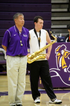Senior Joey Wilson and coach Paul Chiu stand next to each other during the recognition ceremony. Wilson after the ceremony but before the game, played the national anthem on his saxophone. Photo by Christine Liang. 
