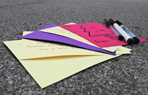 Students wrote thoughtful messages on the brightly colored cards provided for them in the rally court. The cards were dropped off into a box where they would be distributed later in the week. Photo by Jennie Chen.