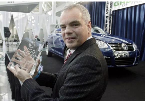 Steven Jacoby, president of Volkswagen in 2009, holds the Green Car of the Year Award. Volkswagen, along with 20 billion dollars in damages, now needs to return the eco-friendly awards it won in the past. Source: Ric Francis — AP 
