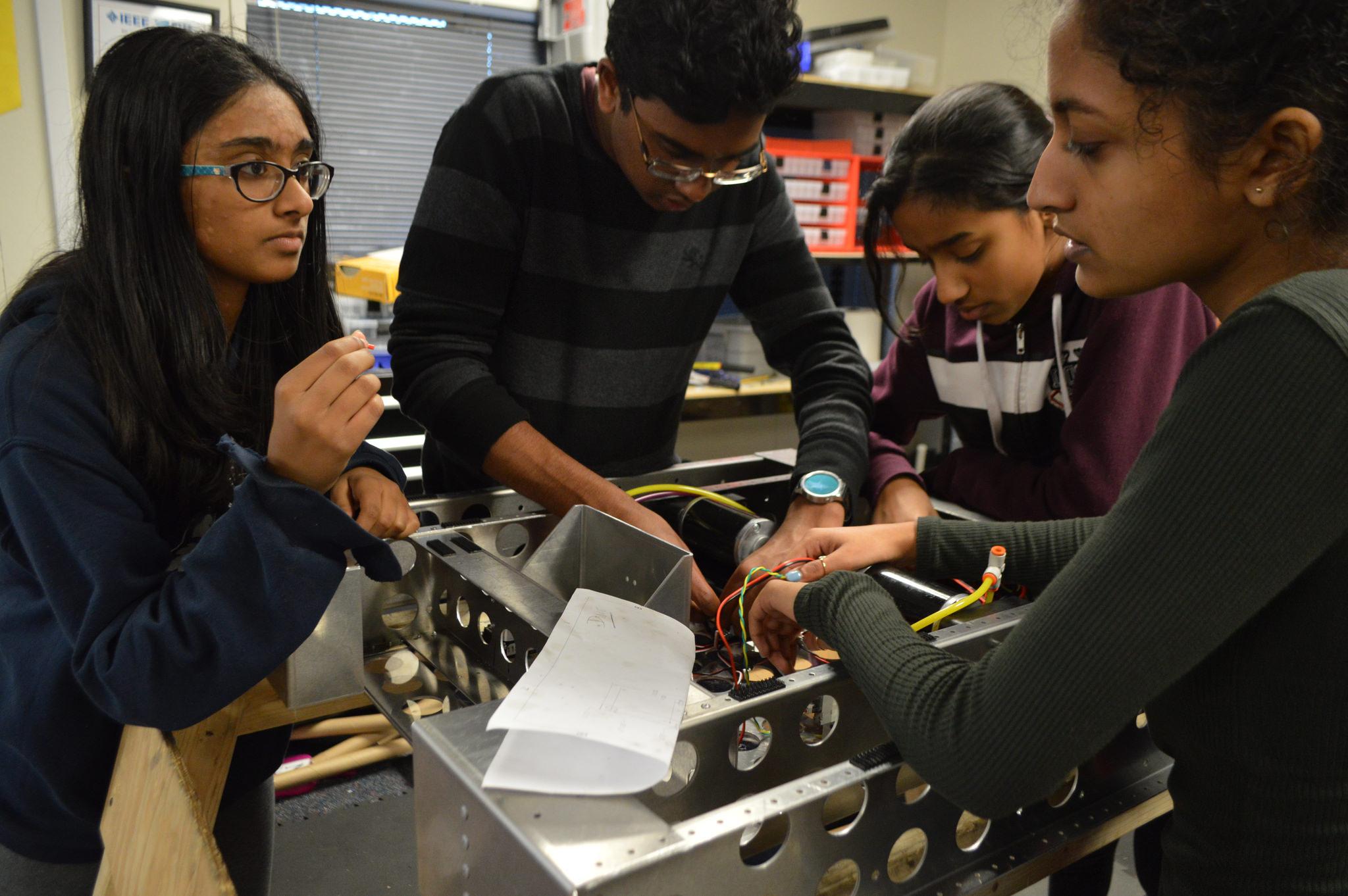 Palla works with three female members to adjust components of the robot. This year, MVRT aims to encourage girls to participate equally throughout the build season.